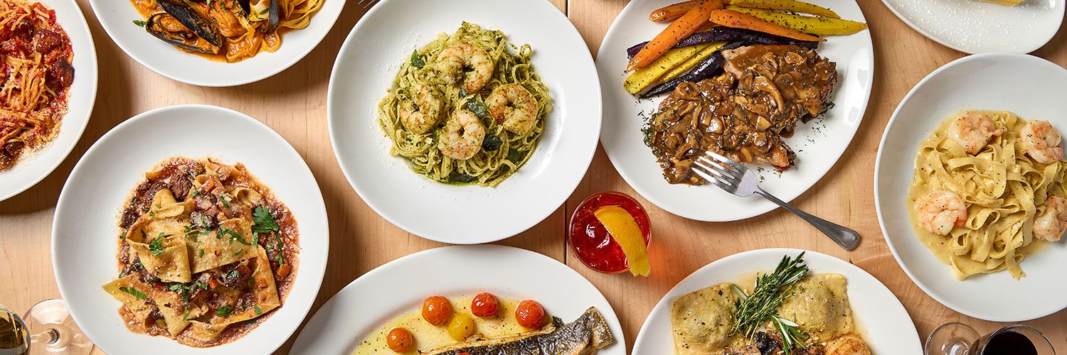 Overhead table shot of multiple Gussie's menu dishes, including many pastas 