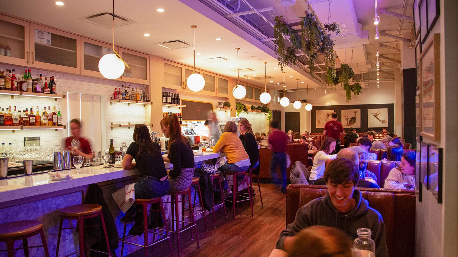 Gussie's busy restaurant in the evening with a view of a few booths and the bar